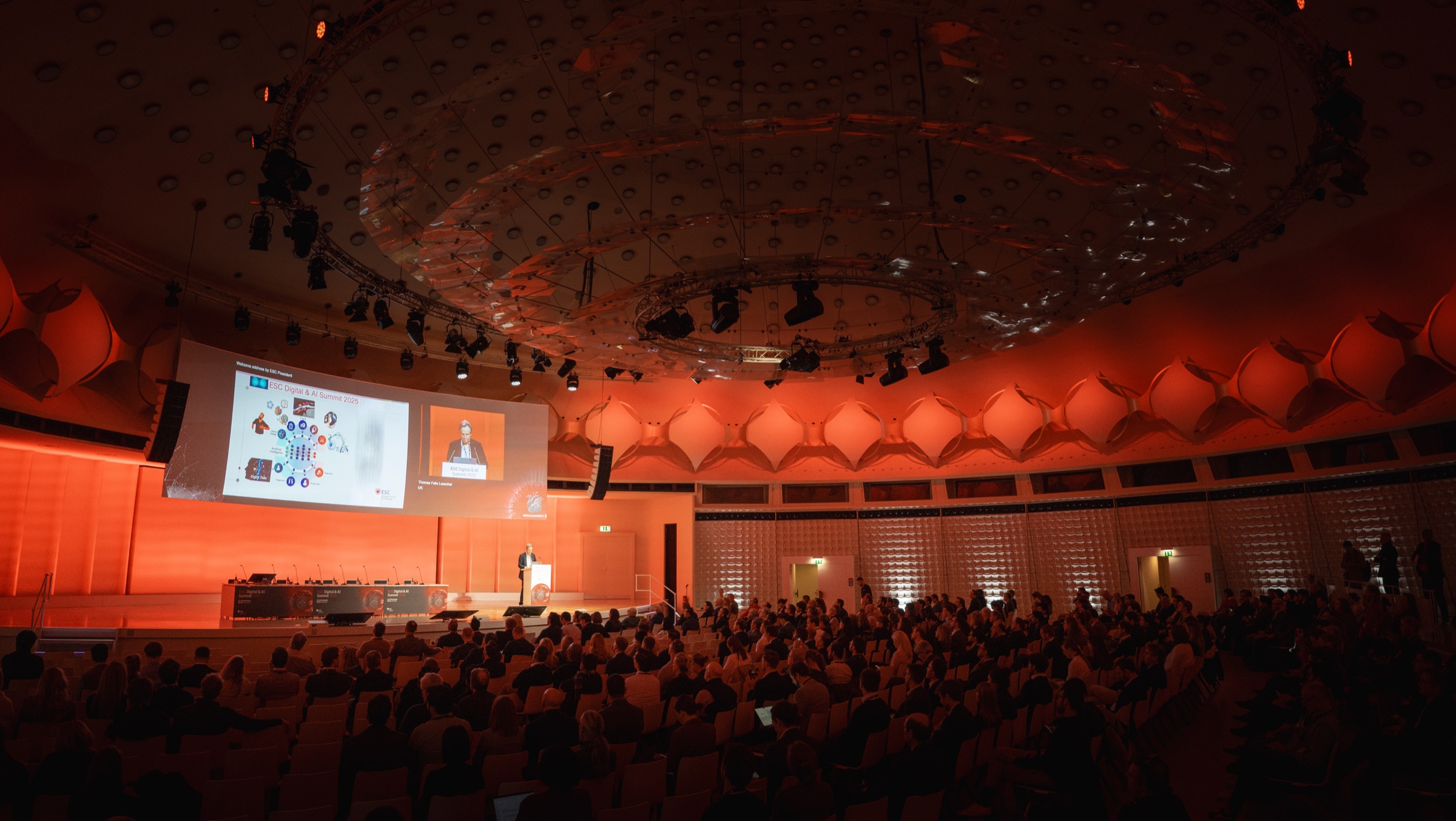 Audience and speaker in the auditorium at the ESC Digital & AI Summit 2025.