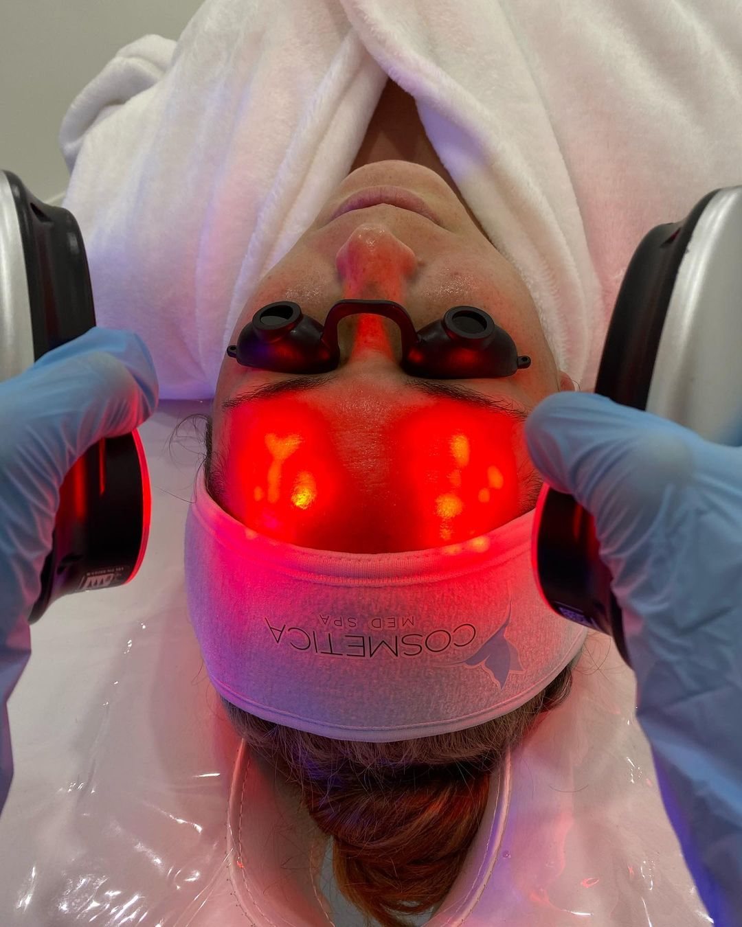 Red LED light therapy handpieces used during a facial at Cosmetica Med Spa