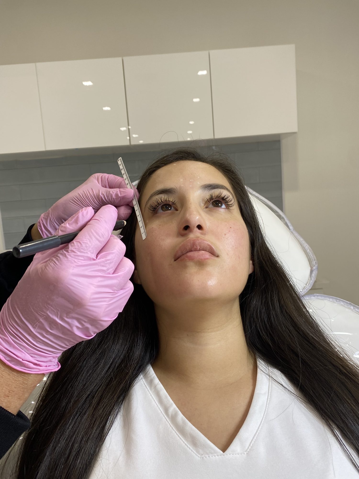 Provider measuring and mapping the brows before Botox at Cosmetica Med Spa