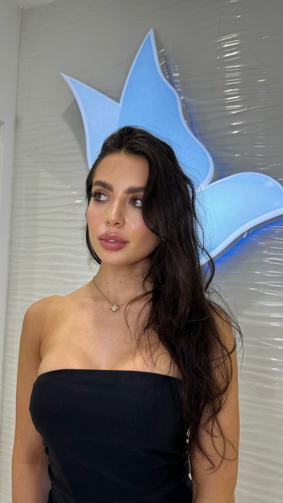 Rocio Baeza in front of the Cosmetica Med Spa logo in Boca Raton