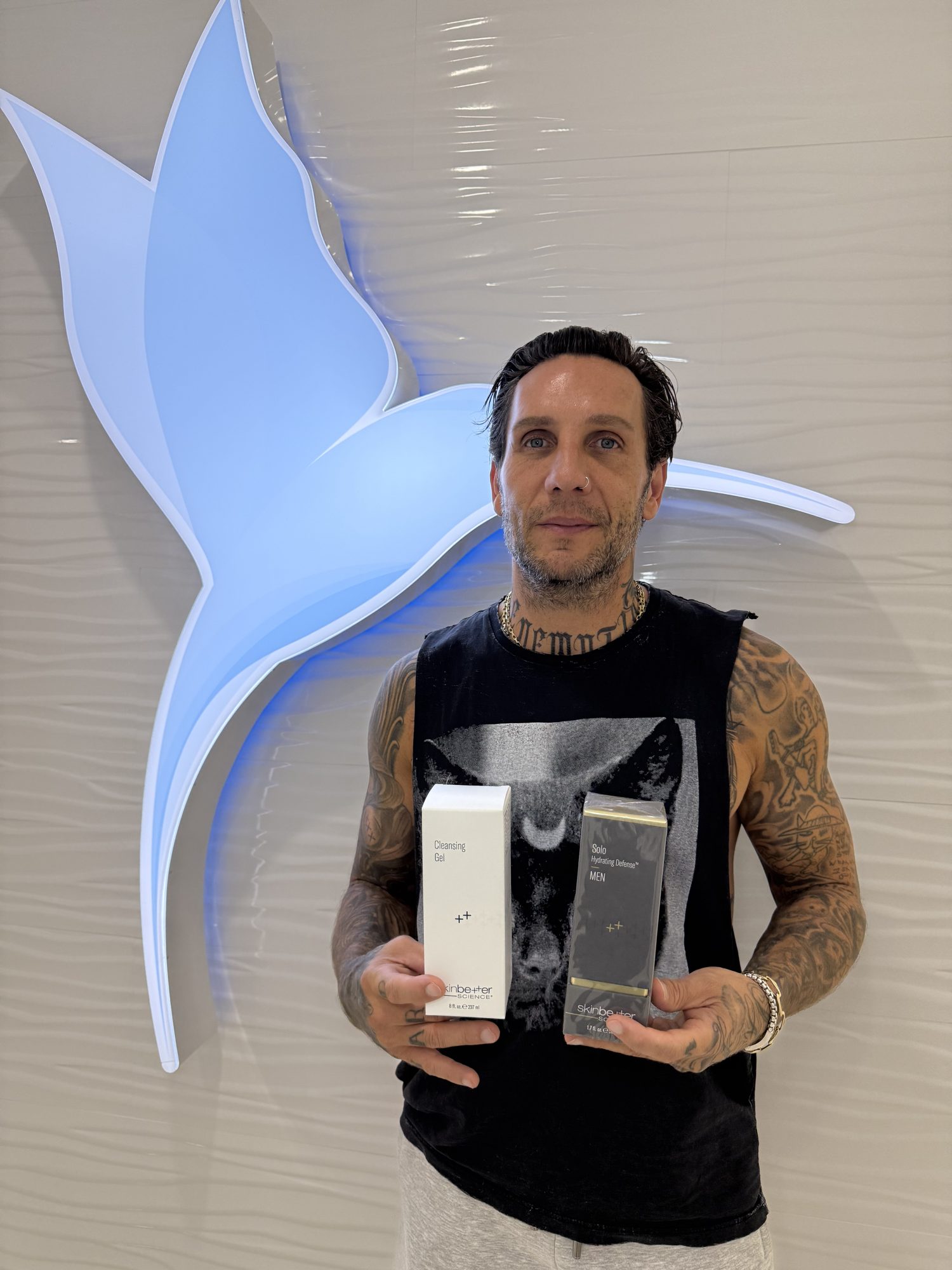 Brandon Novak holding Skinbetter Science men's skin care at Cosmetica Med Spa in Boca Raton