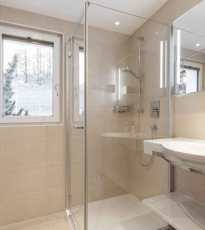 Badezimmer mit Glasdusche und Lavabo