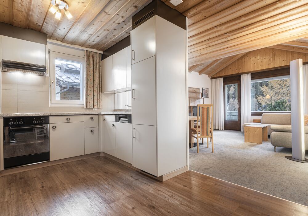Offene Küche mit Holzdecke und Blick in den Wohnbereich