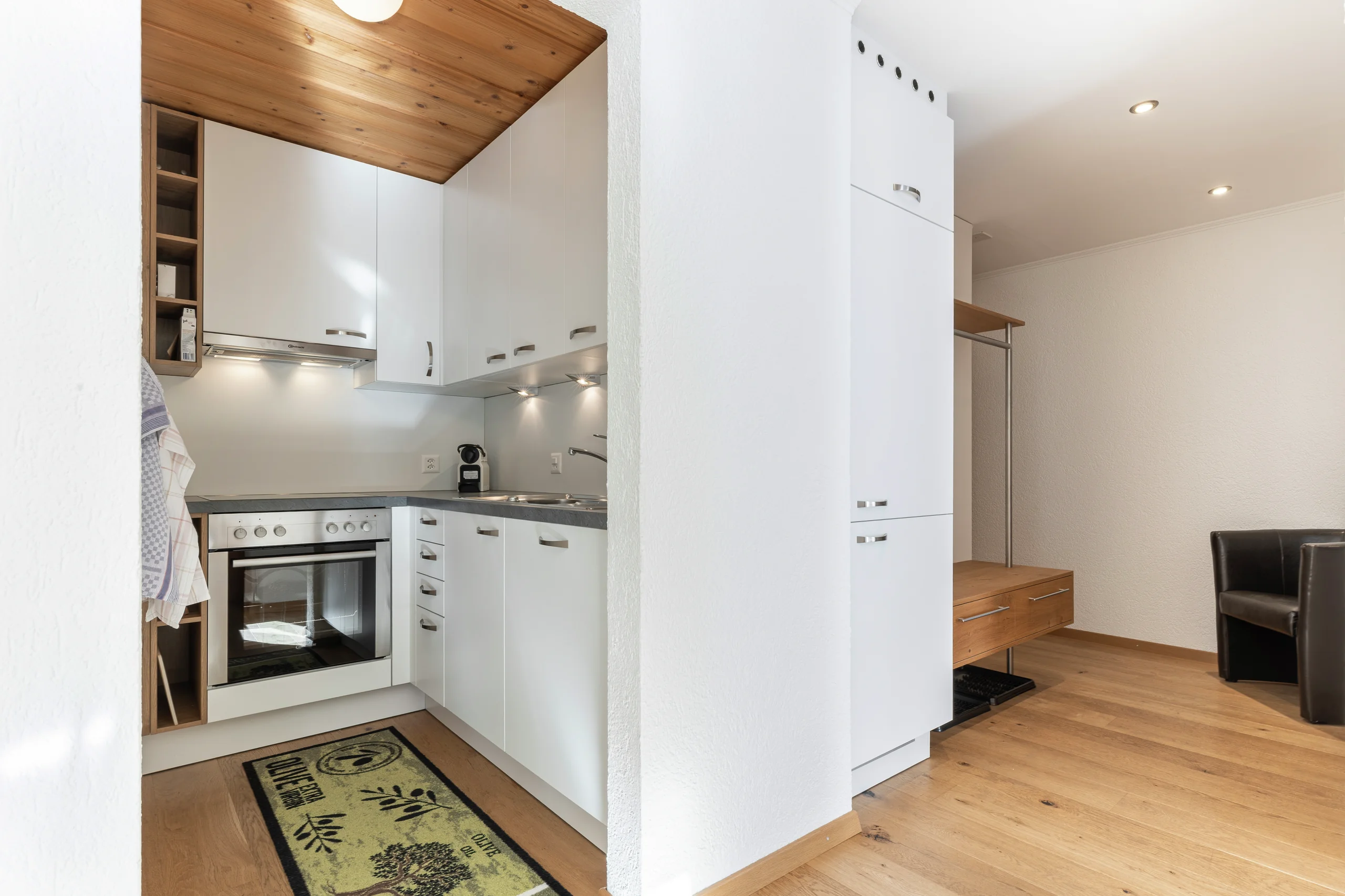 Weisse Küche mit Backofen neben dem Eingangsbereich, Wohnung 102