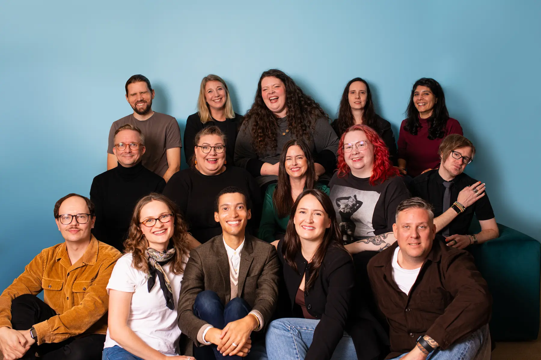 The San Francisco Agency team in a group portrait against a blue wall