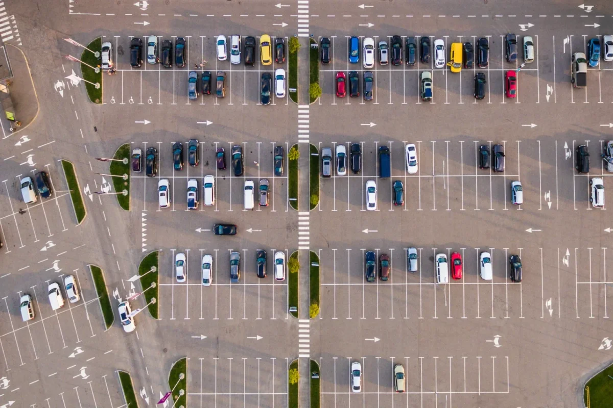 Aerial view of a busy parking lot filled with rows of cars