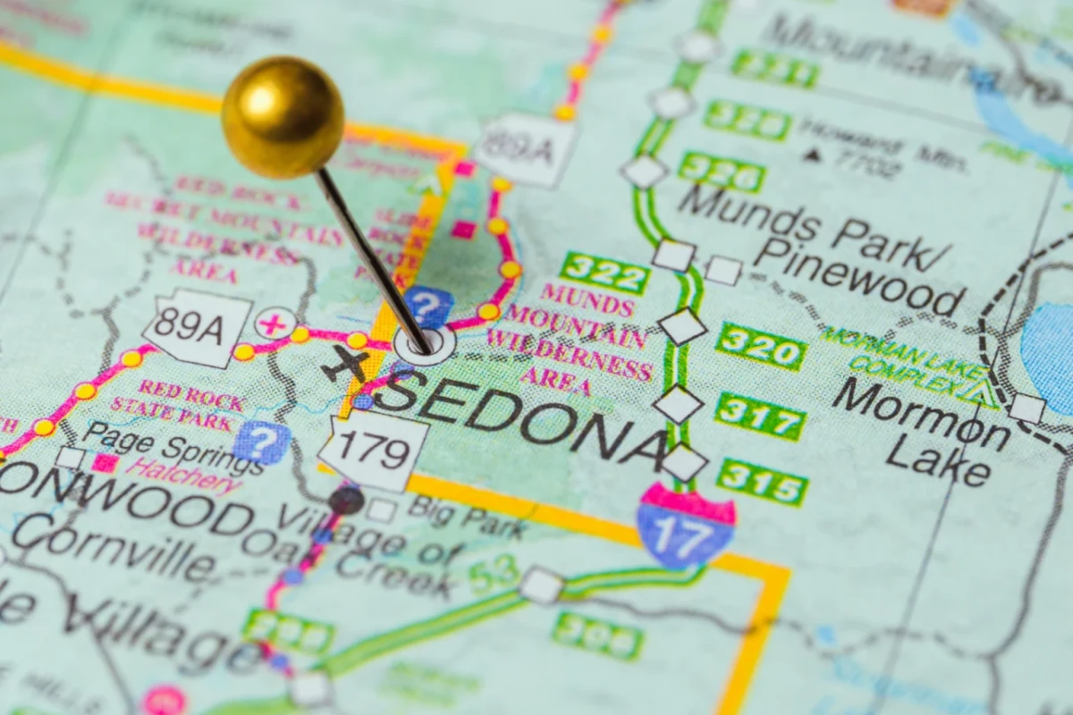 Gold pushpin marking Sedona on a road map with nearby highways