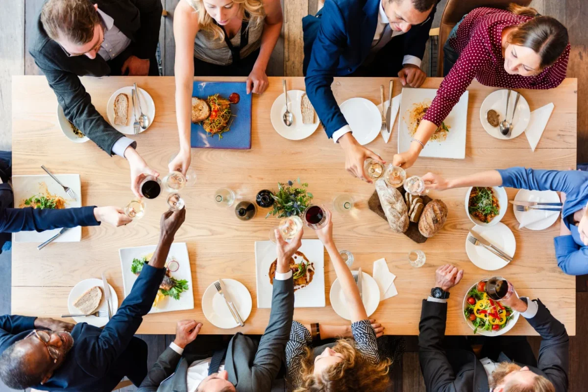 Overhead view of colleagues sharing a meal around a long table