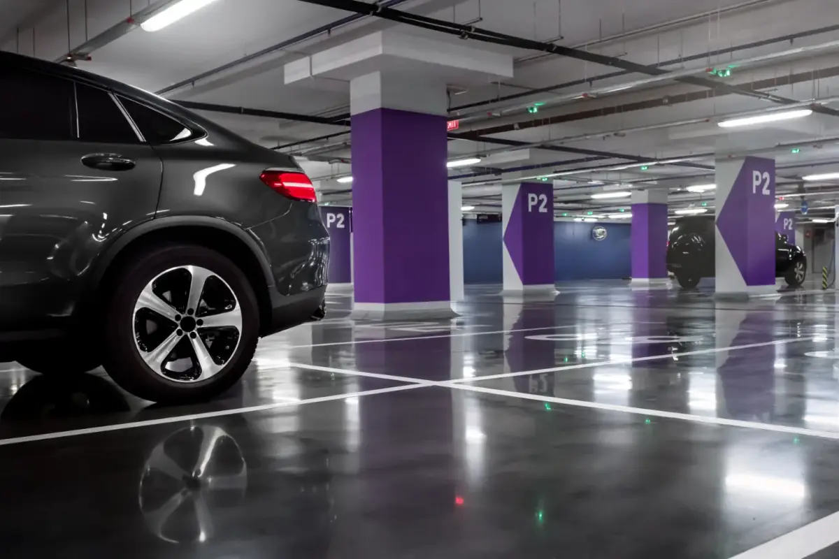 Car parked in an underground garage with purple pillars marked P2