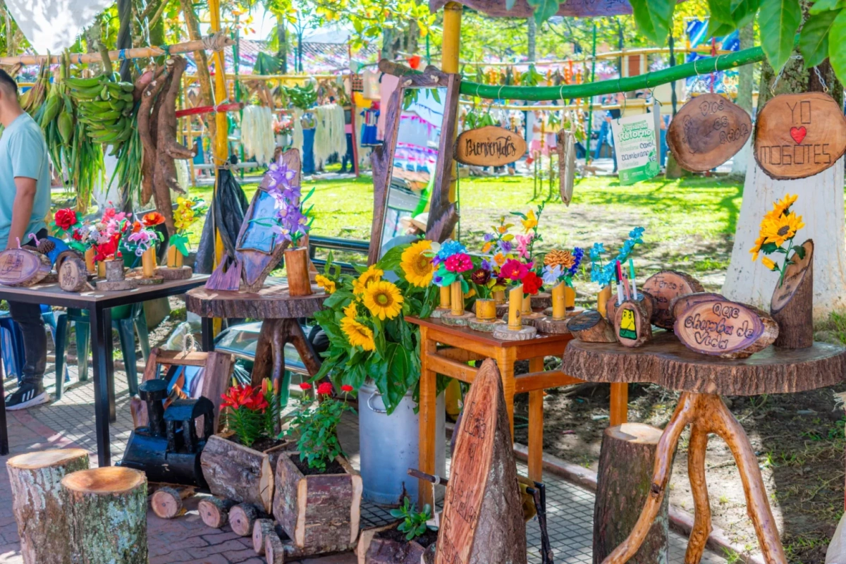 Outdoor craft fair booths with sunflowers, wooden decor and string lights