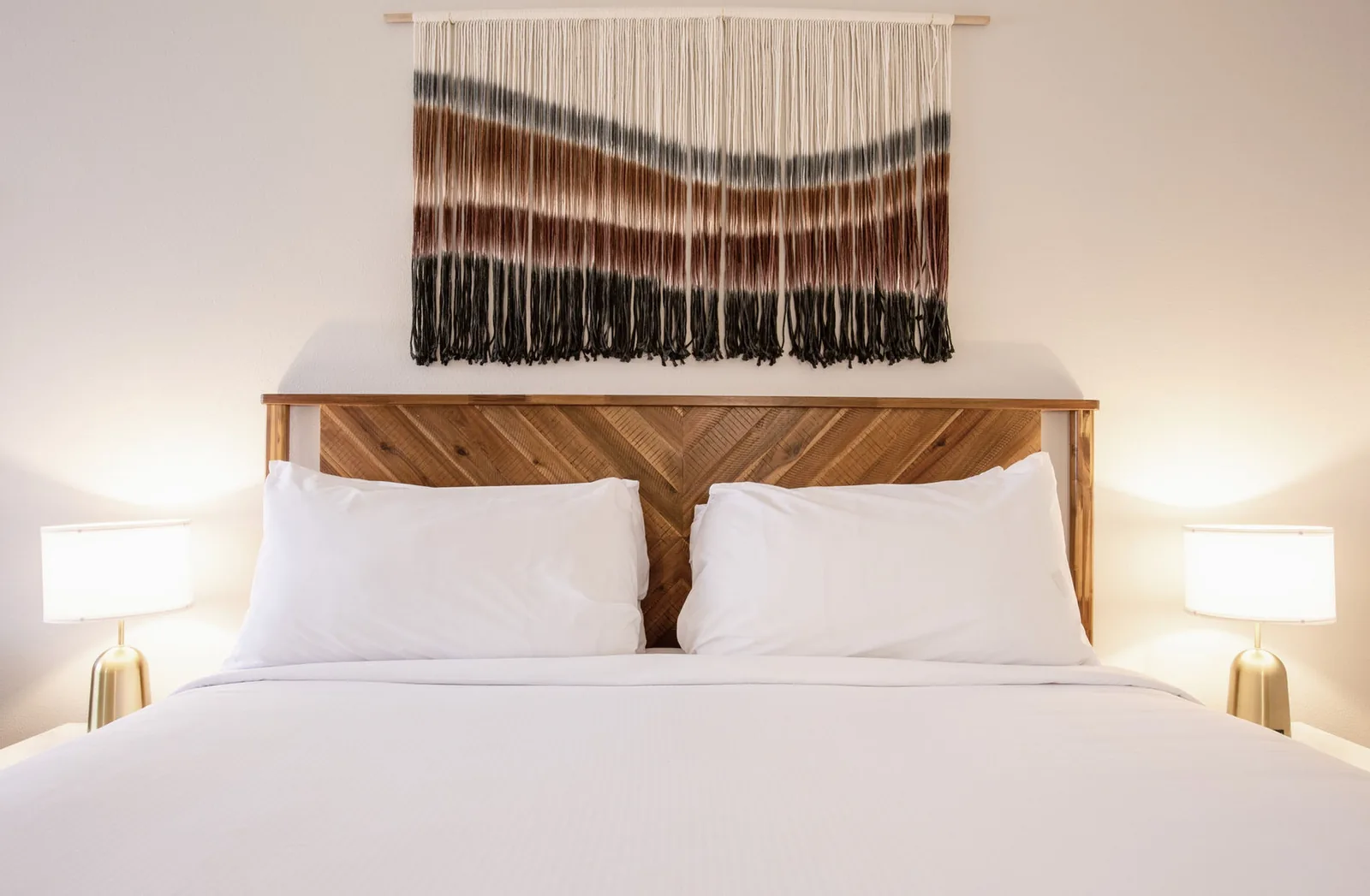 One King Bed room at Kokopelli Inn Sedona with wood headboard and woven wall hanging