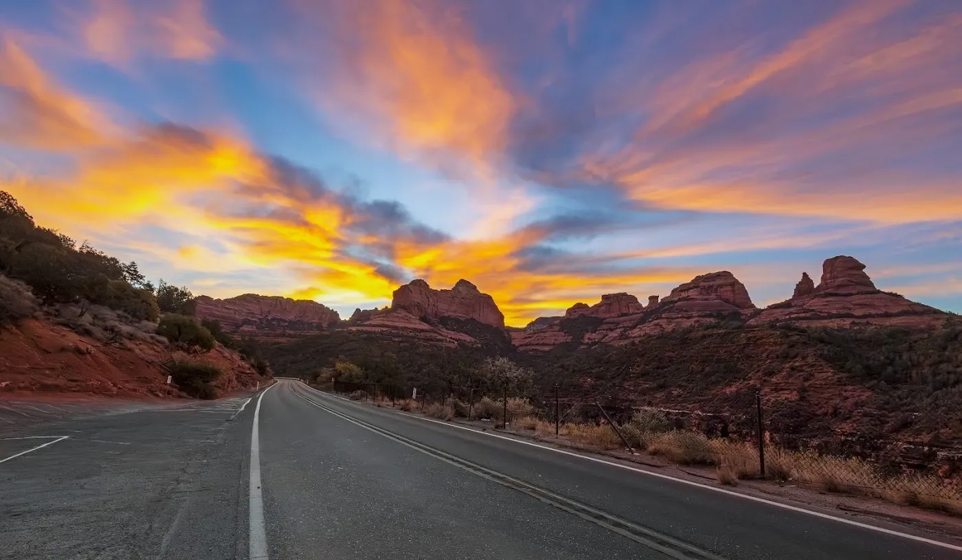 Sunset over a scenic road through Sedona’s red rocks