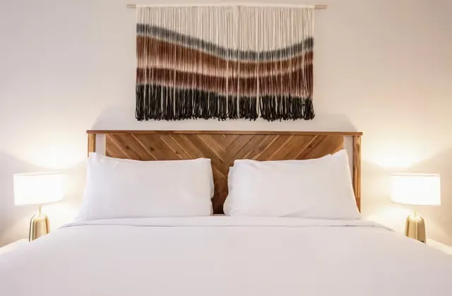 One King Bed room at Kokopelli Inn Sedona with wood headboard and woven wall hanging