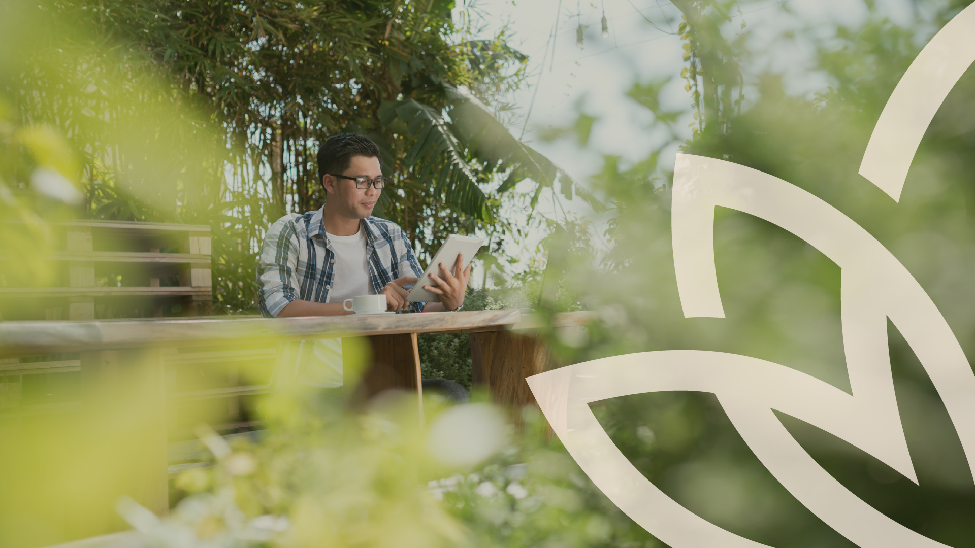 Man working at a laptop surrounded by plants
