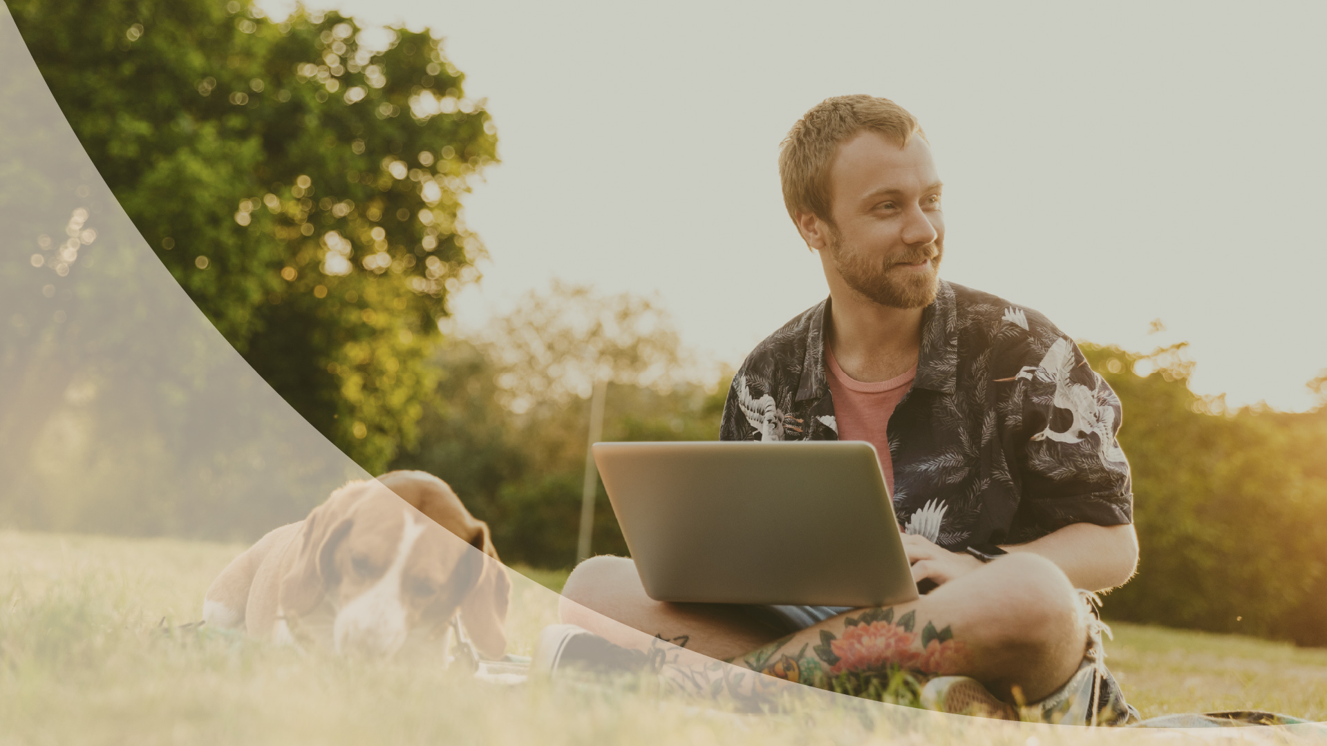 Man relaxing on the grass with a laptop