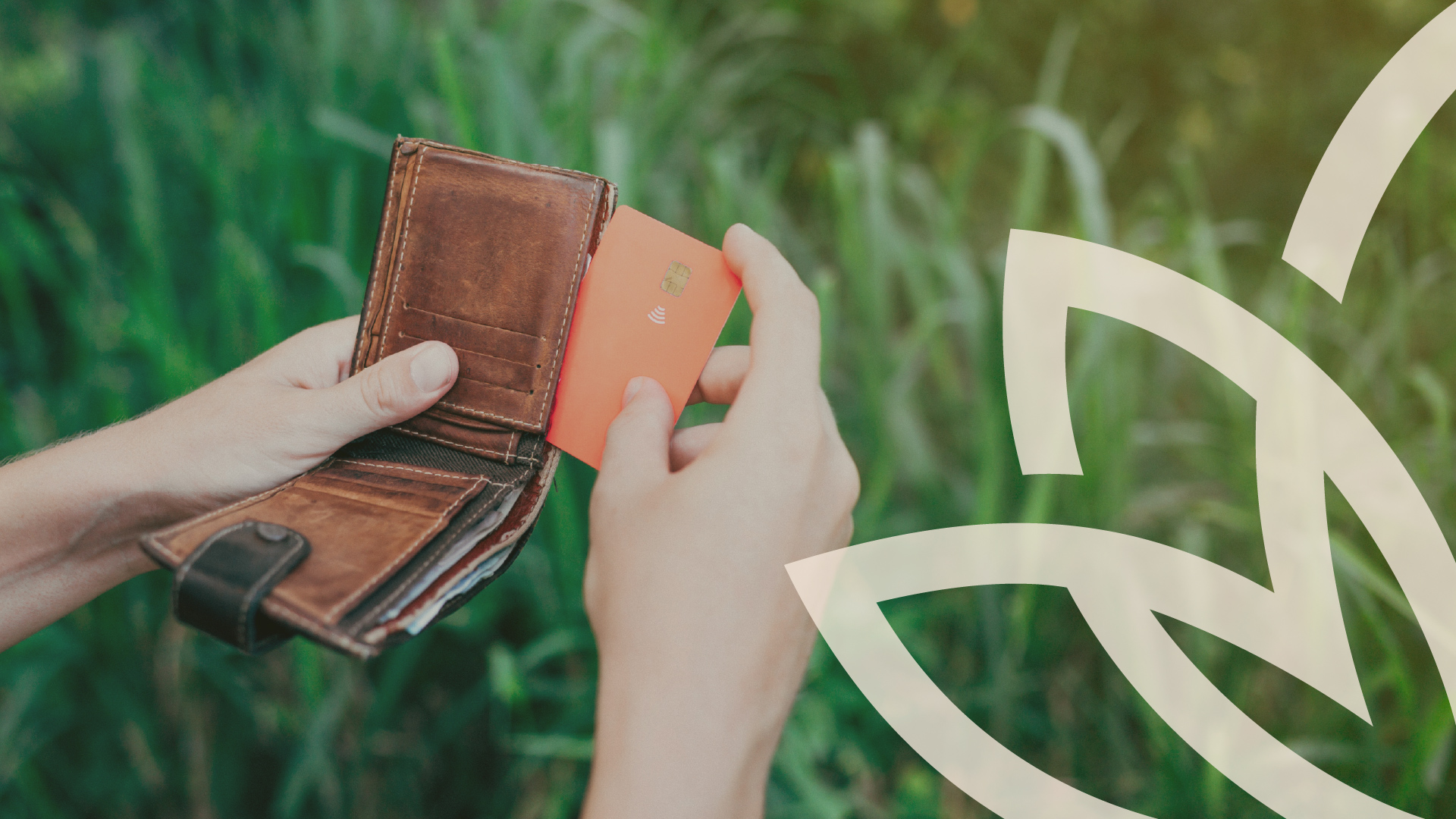 Hand pulling a card from a leather wallet outdoors