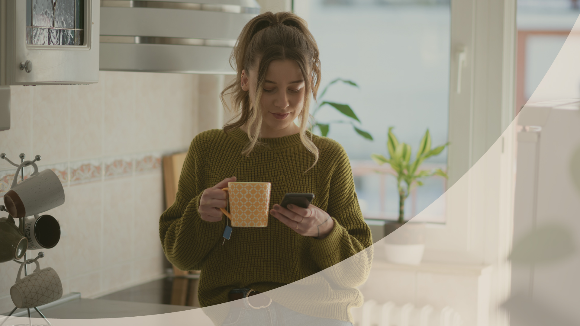 Woman holding a mug and looking at her phone