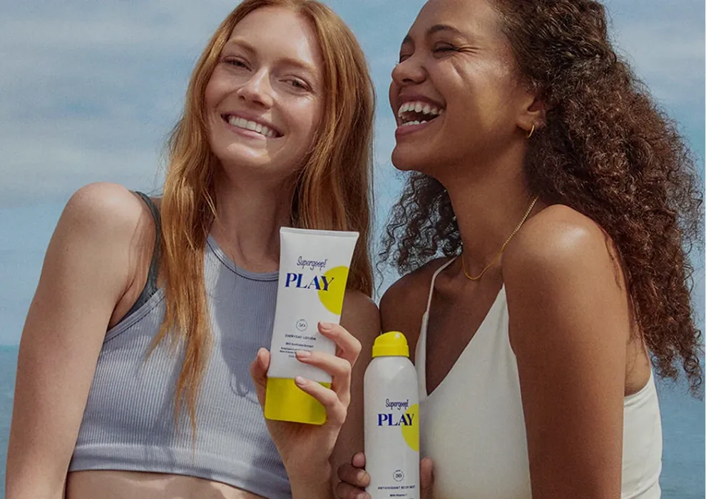 Two women at the beach holding Supergoop PLAY sunscreen