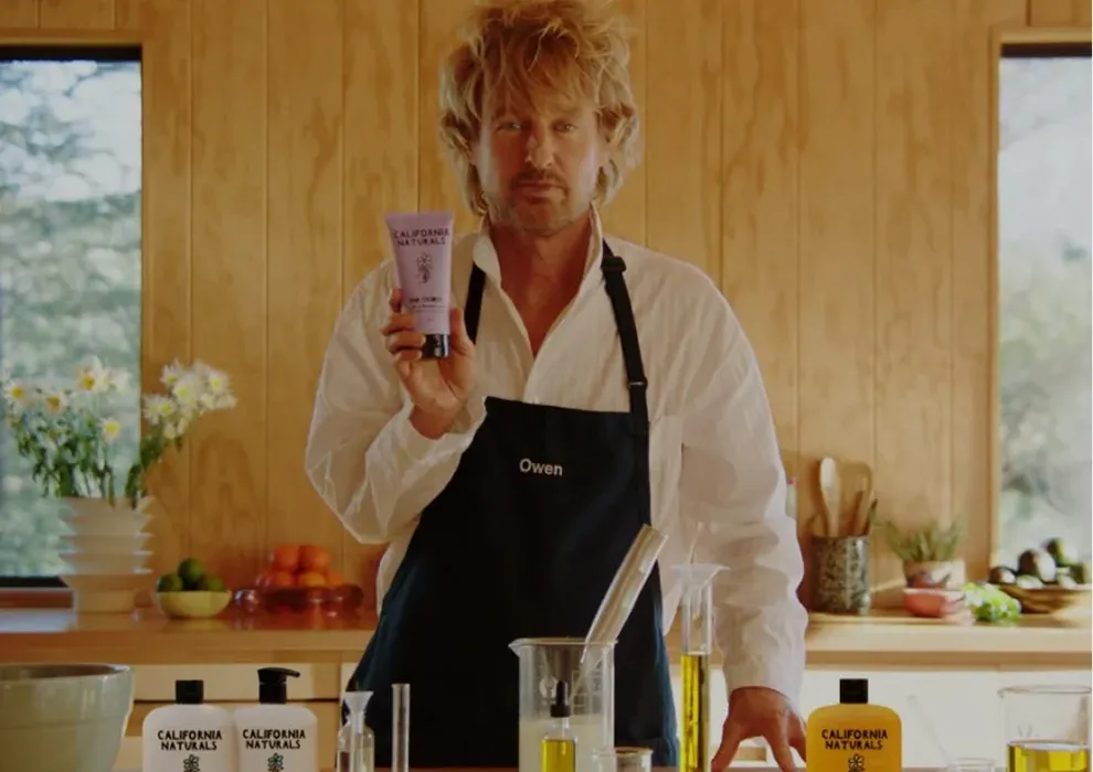 Man in an apron holding a California Naturals product in a kitchen