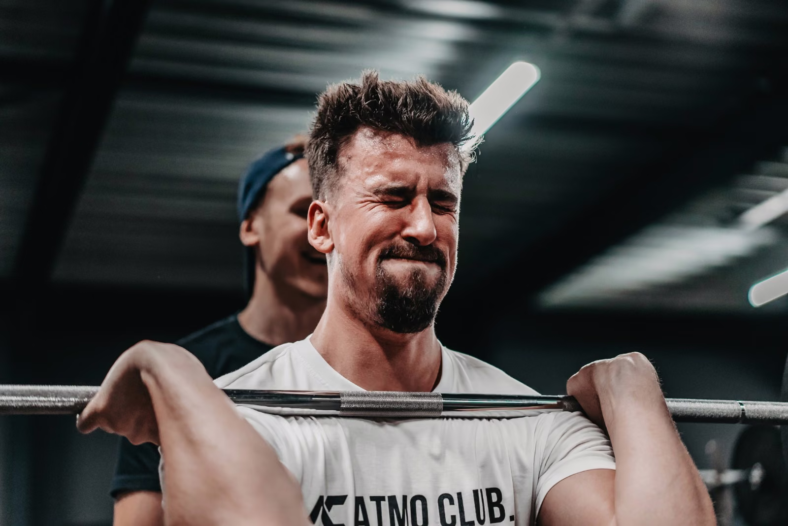 Mitglied mit voller Anstrengung beim Langhanteltraining