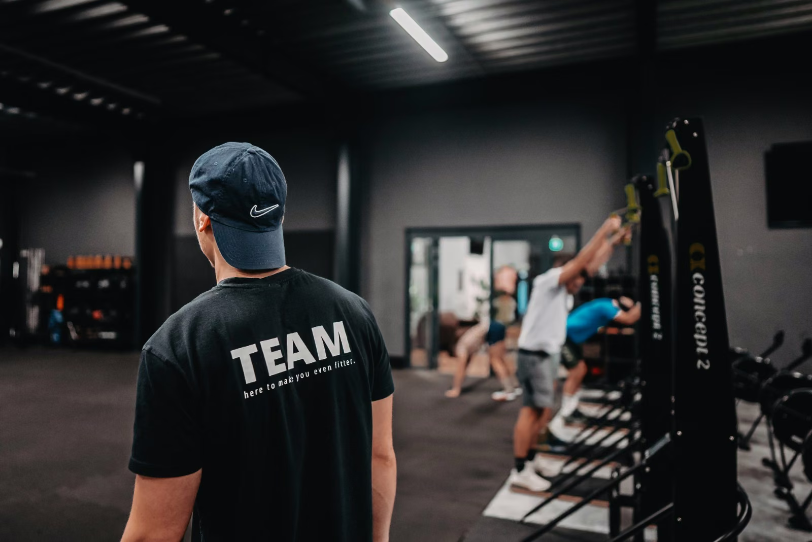 Coach beobachtet die Gruppe an den Stationen im HYROX-Kurs