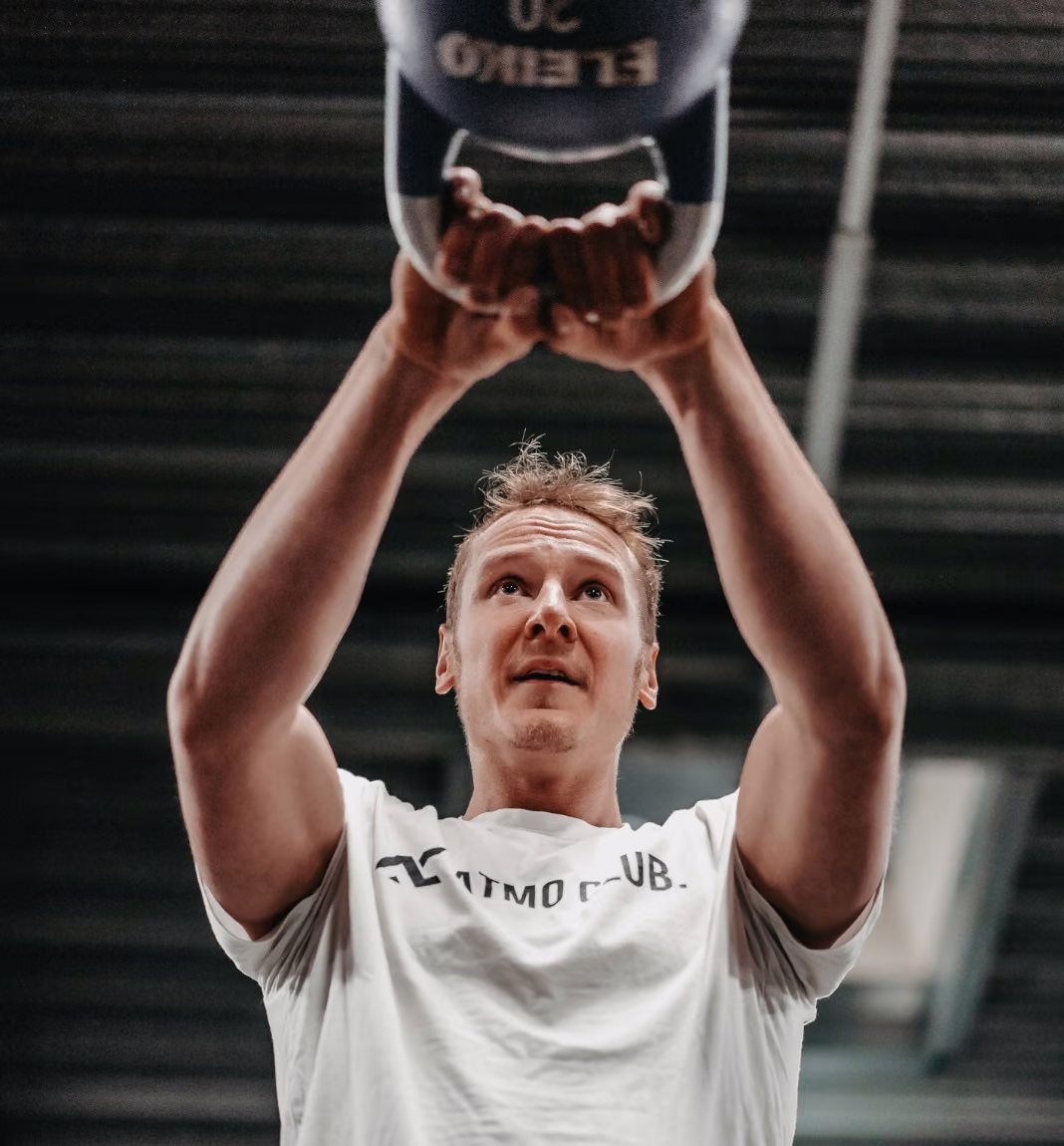 Mitglied drückt eine Kettlebell über Kopf im Open Gym des ATMO Club