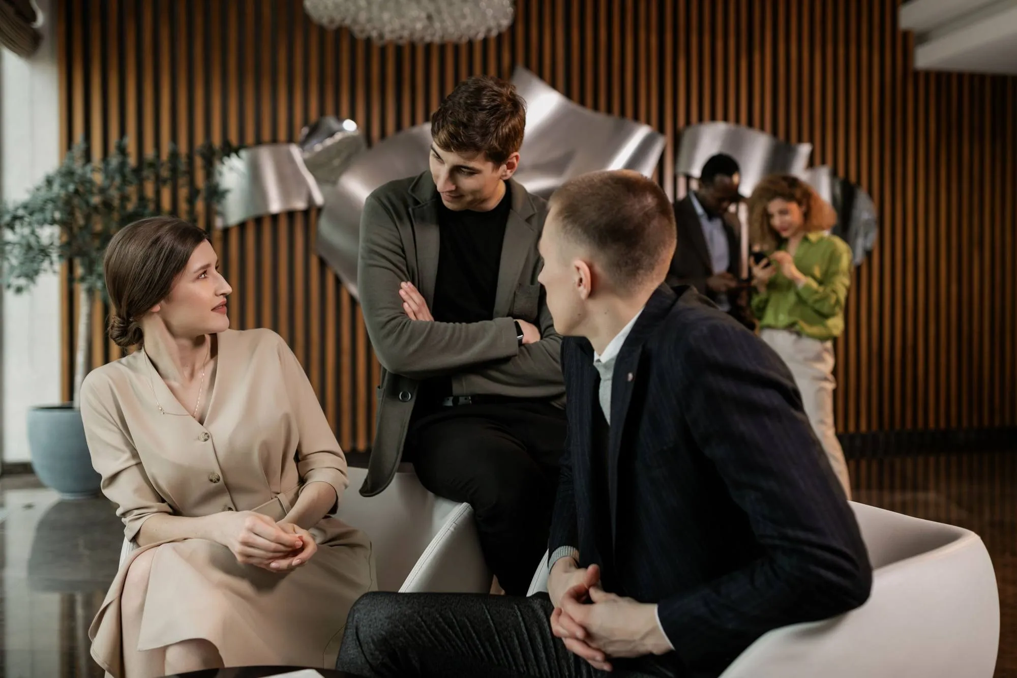Three colleagues in conversation in an office lounge