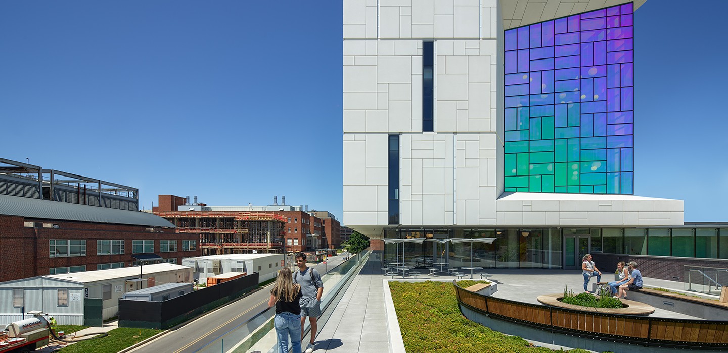 Exterior view of the IDEA Factory building's colored-glass window wall and second-floor terrace