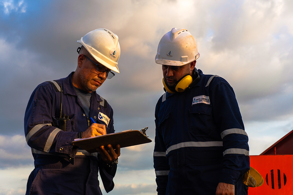Two NABEP crew members reviewing a checklist on site