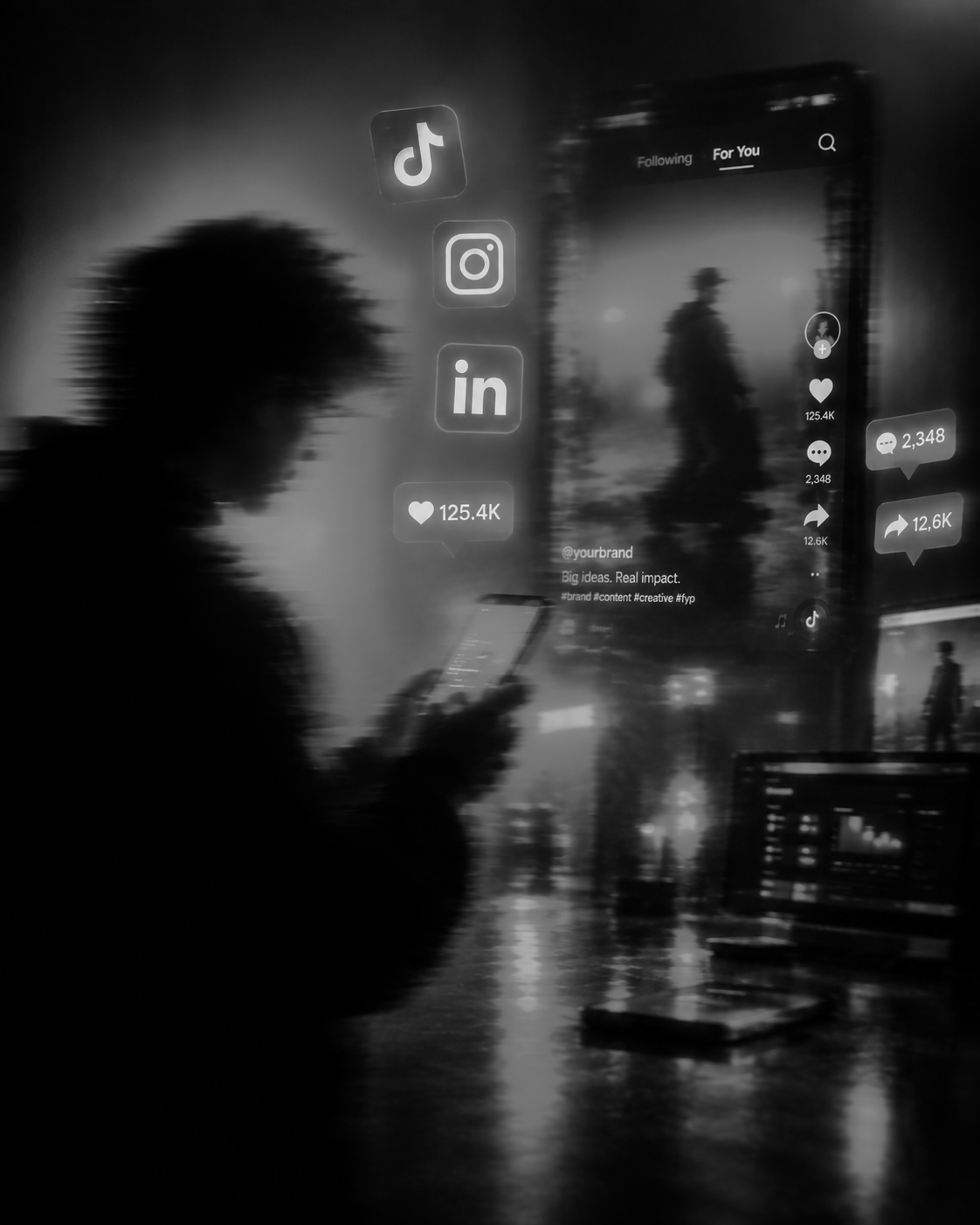 Person am Handy und im Hintergrund hat es Laptop und Like und Teilen Symbole in der Luft.