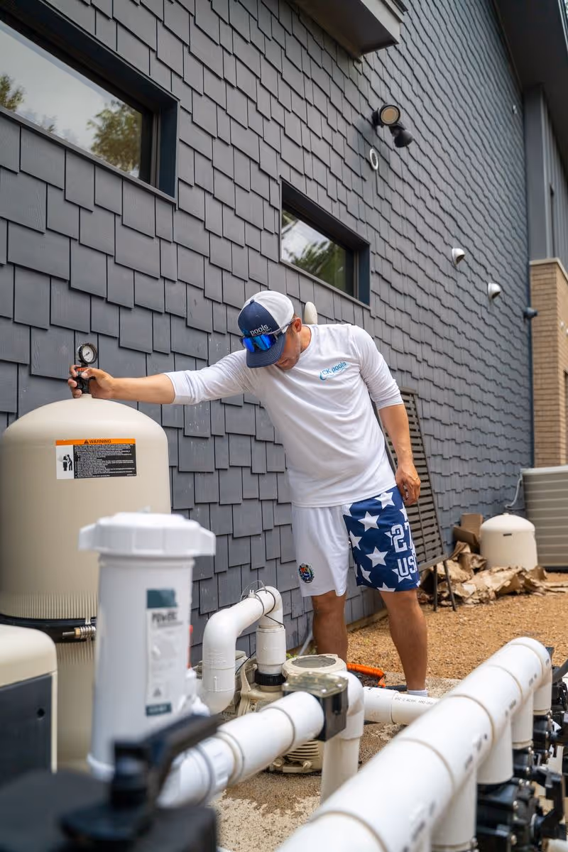 CK Pools technician inspecting residential pool filtration equipment