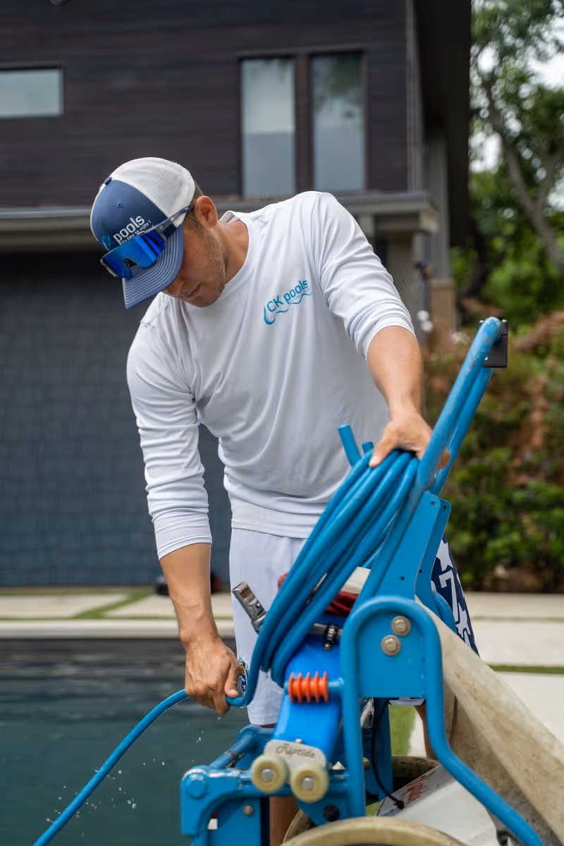 Pool technician operating professional pool cleaning equipment