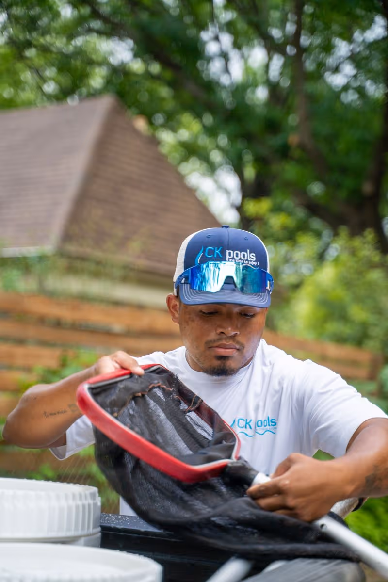 CK Pools technician cleaning a pool filter basket
