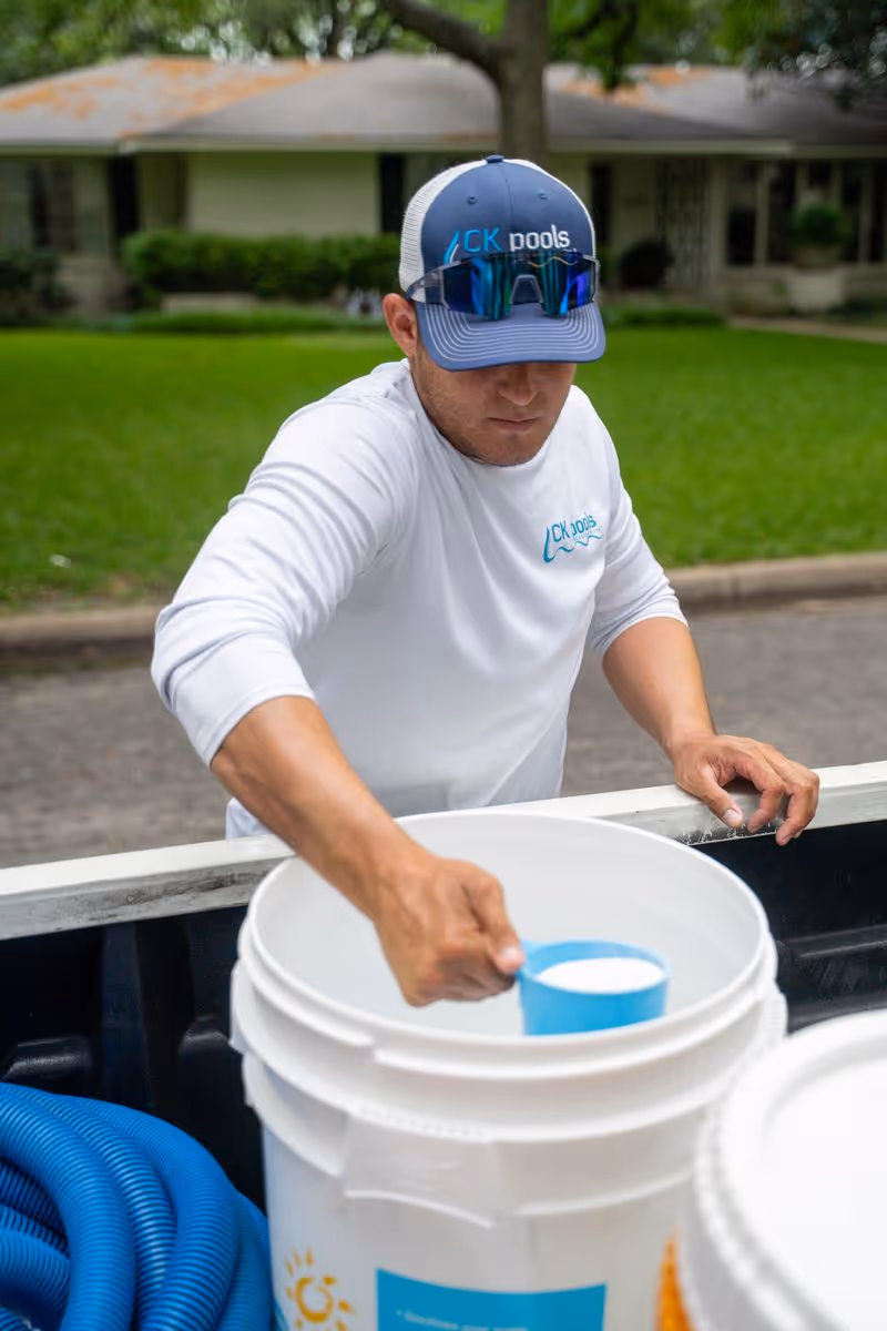 CK Pools technician measuring chemicals for customized pool maintenance