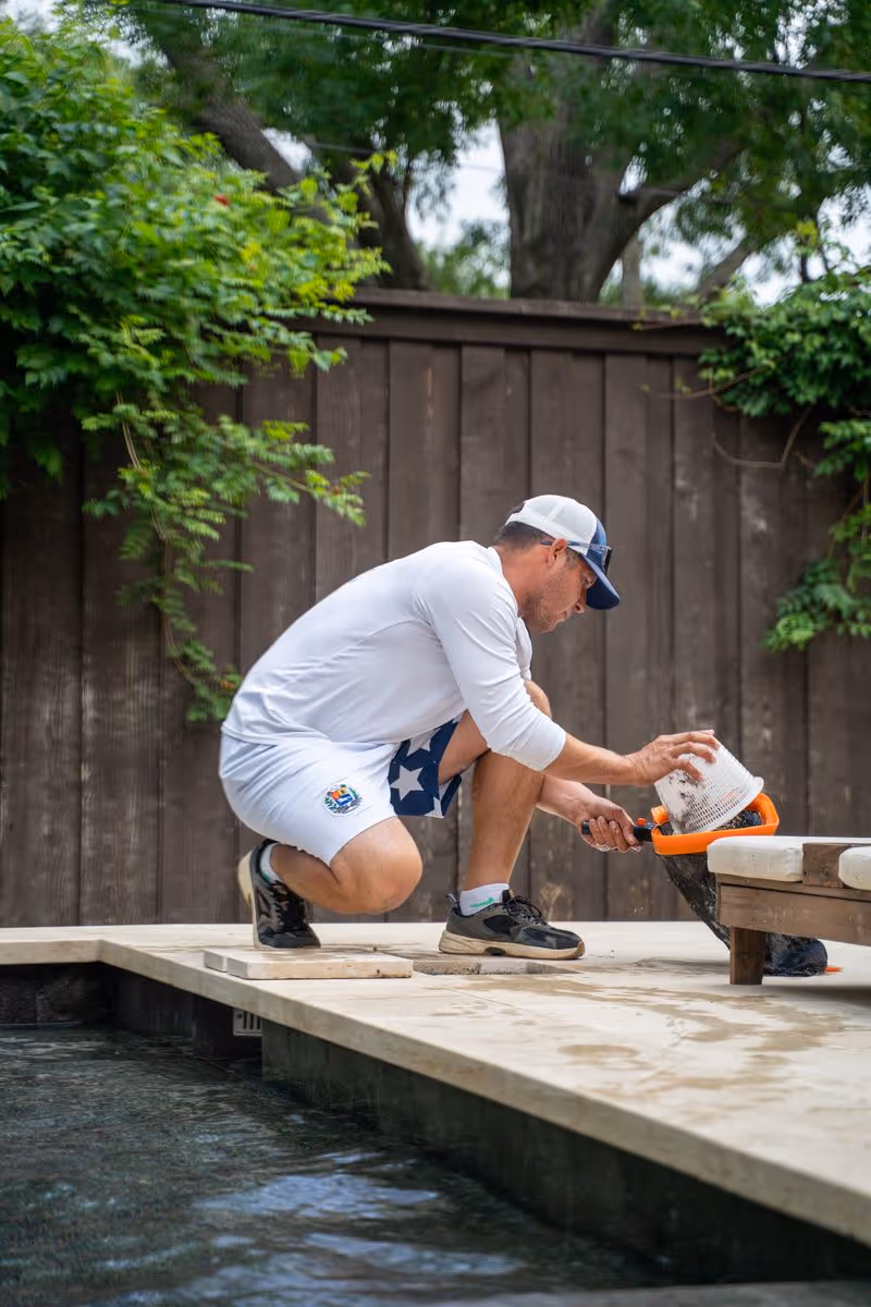 CK Pools technician preparing supplies beside a residential pool