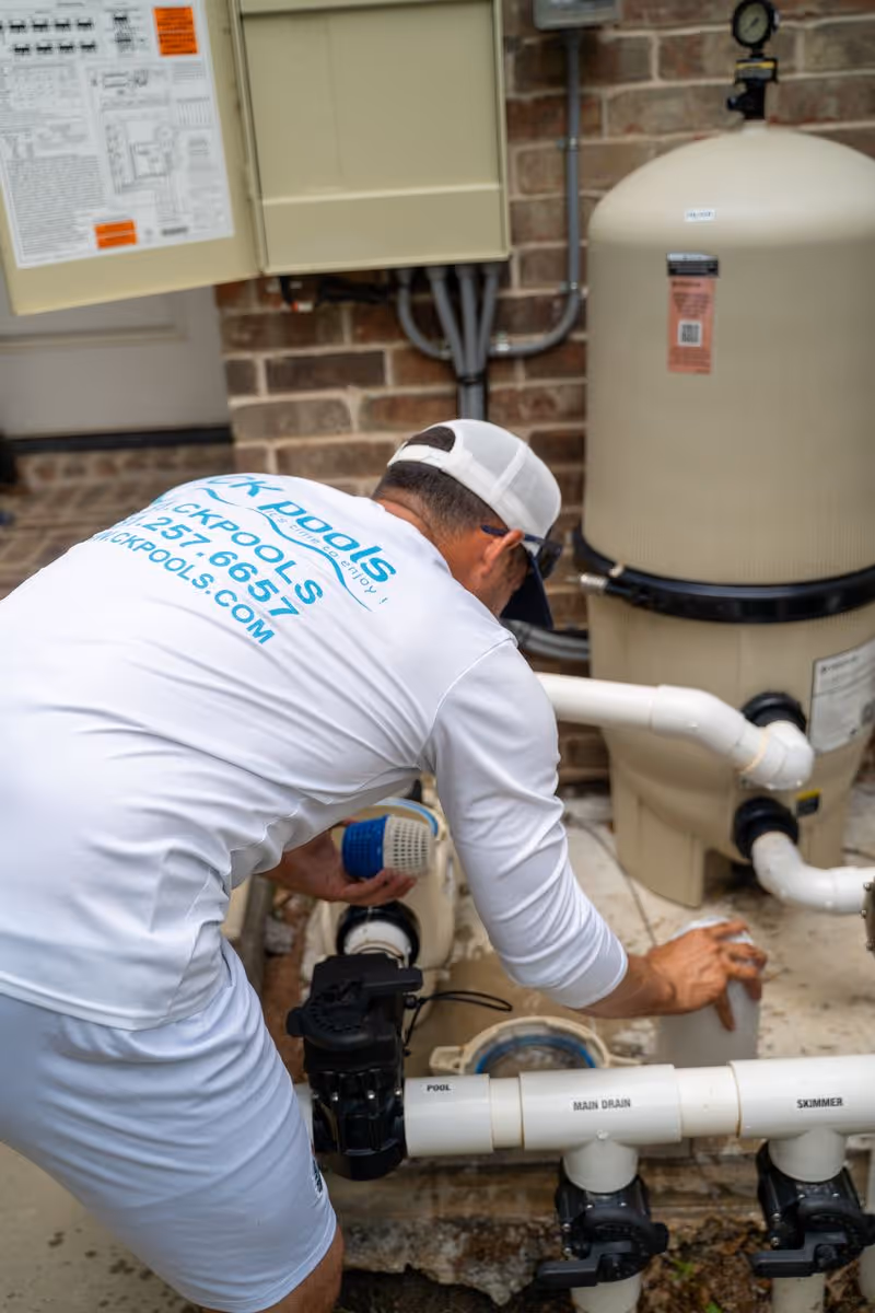CK Pools technician servicing pool filtration equipment at a residential property