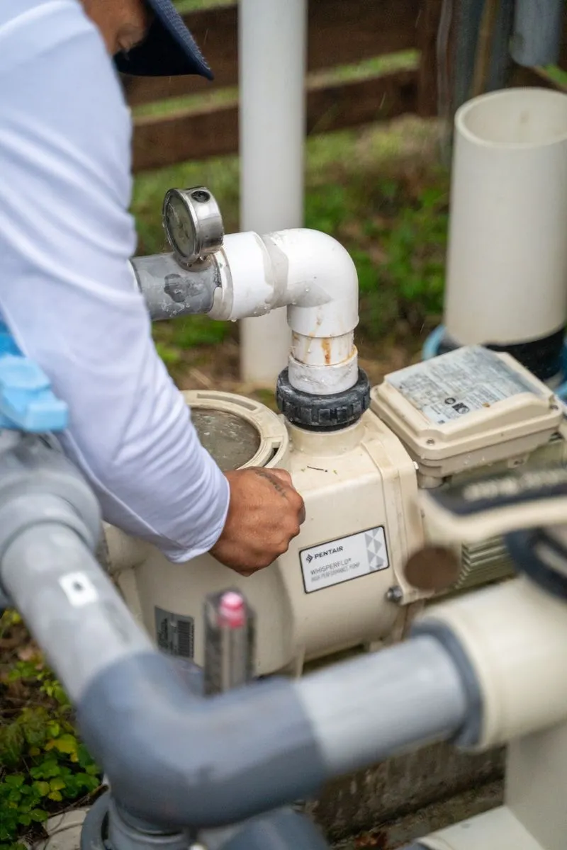 Pool technician inspecting a pump and filtration system