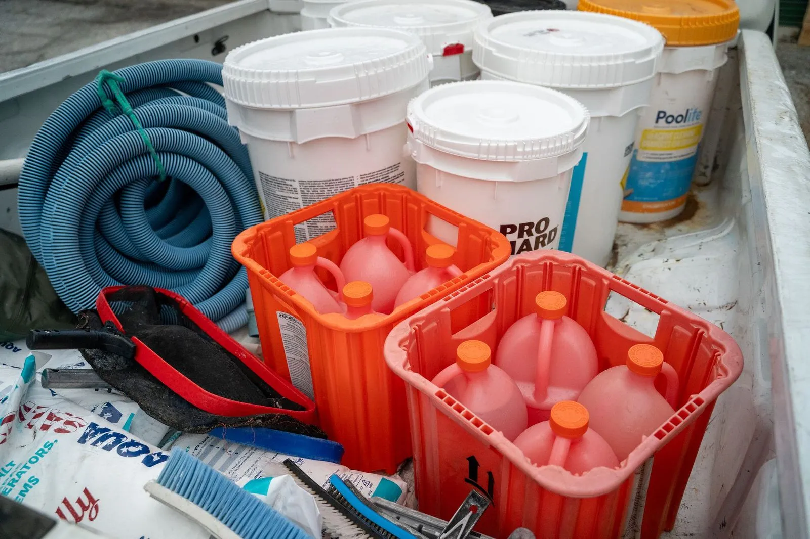 Pool chemicals, hoses, and maintenance equipment in a CK Pools service truck