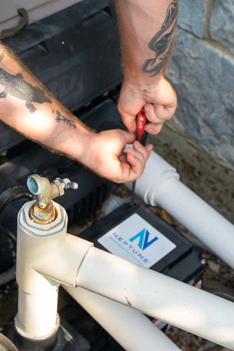 Pool repair technician working on pipes and filtration equipment