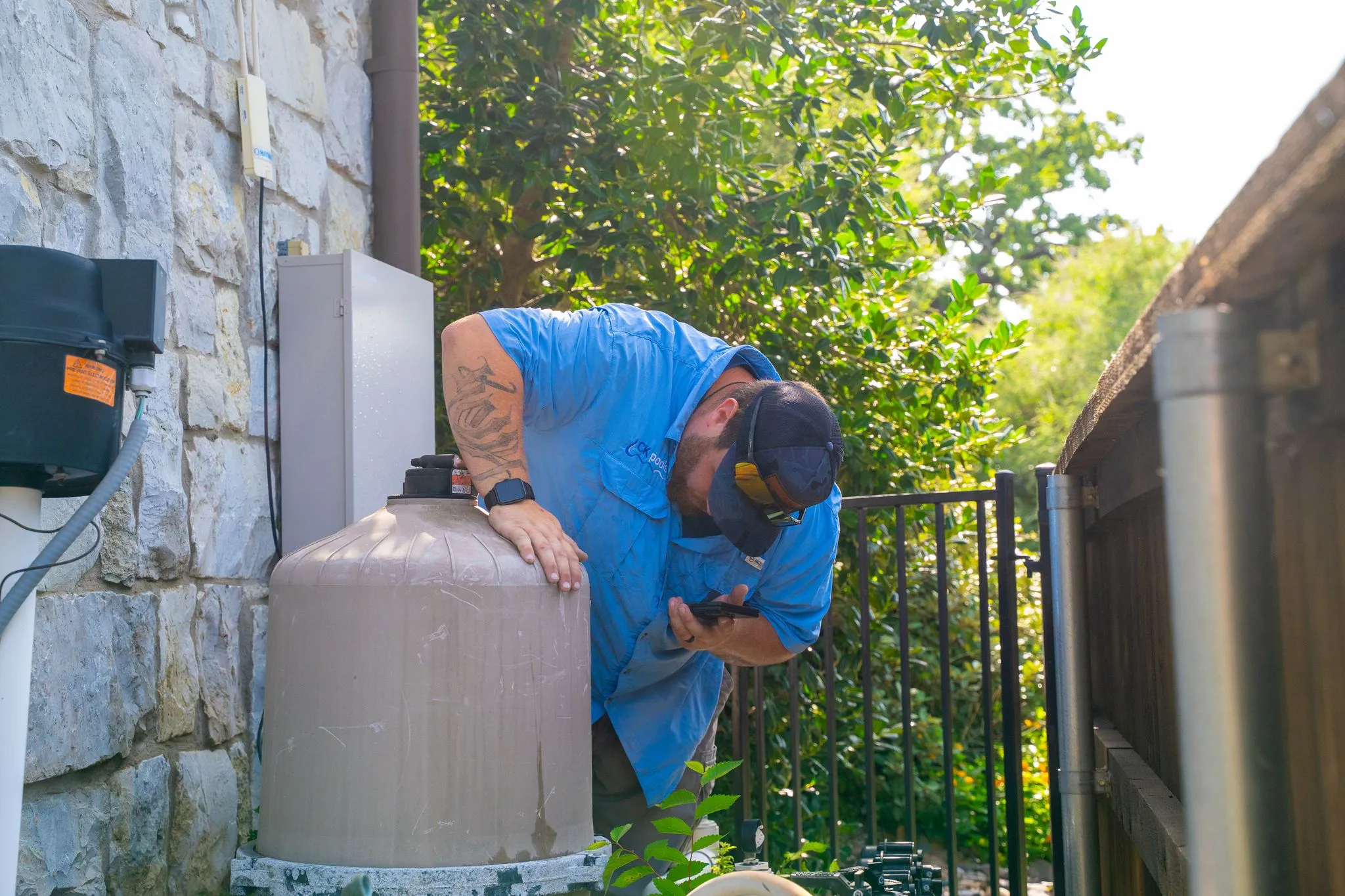 CK Pools technician inspecting a pool filter tank