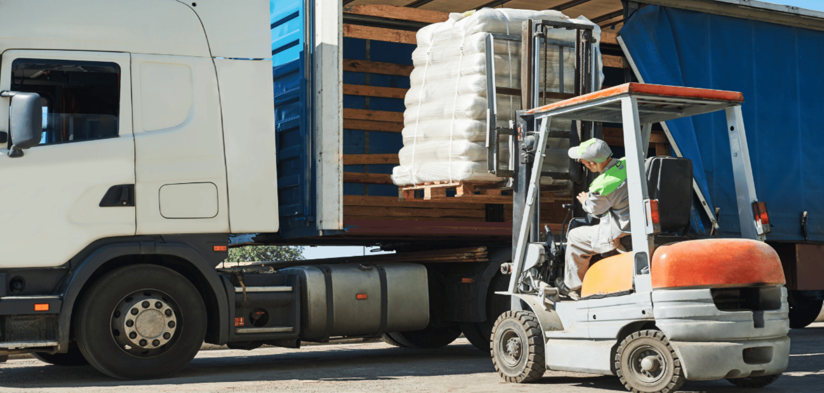 Forklift loading palletized bags onto a truck