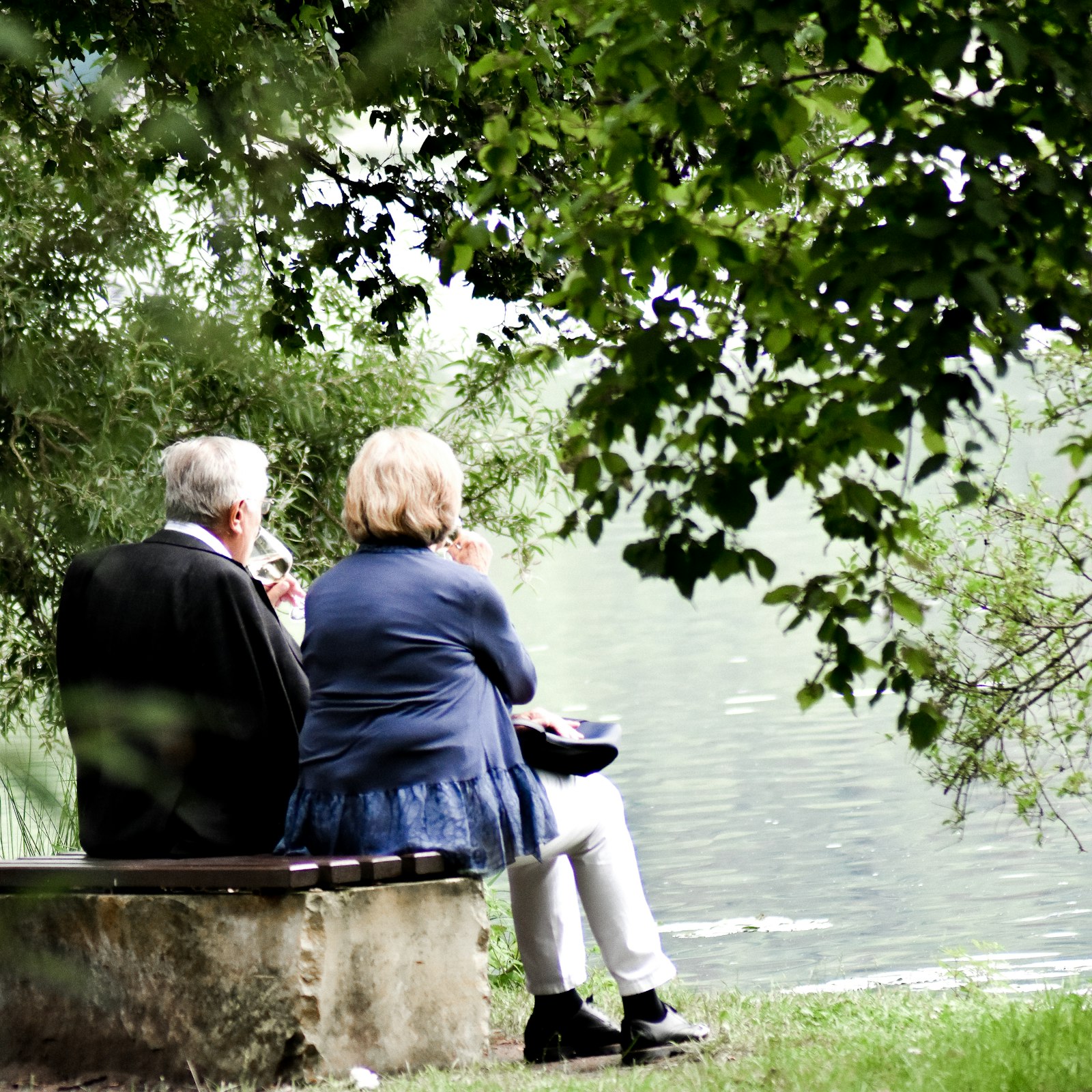 Couple relaxing on a lakeside bench