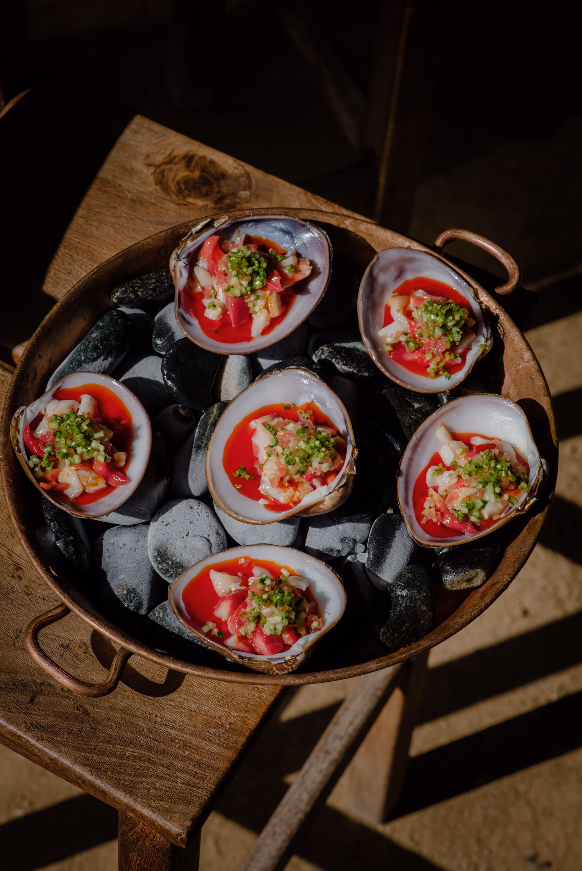 Tray of fresh oysters with red garnish on ice