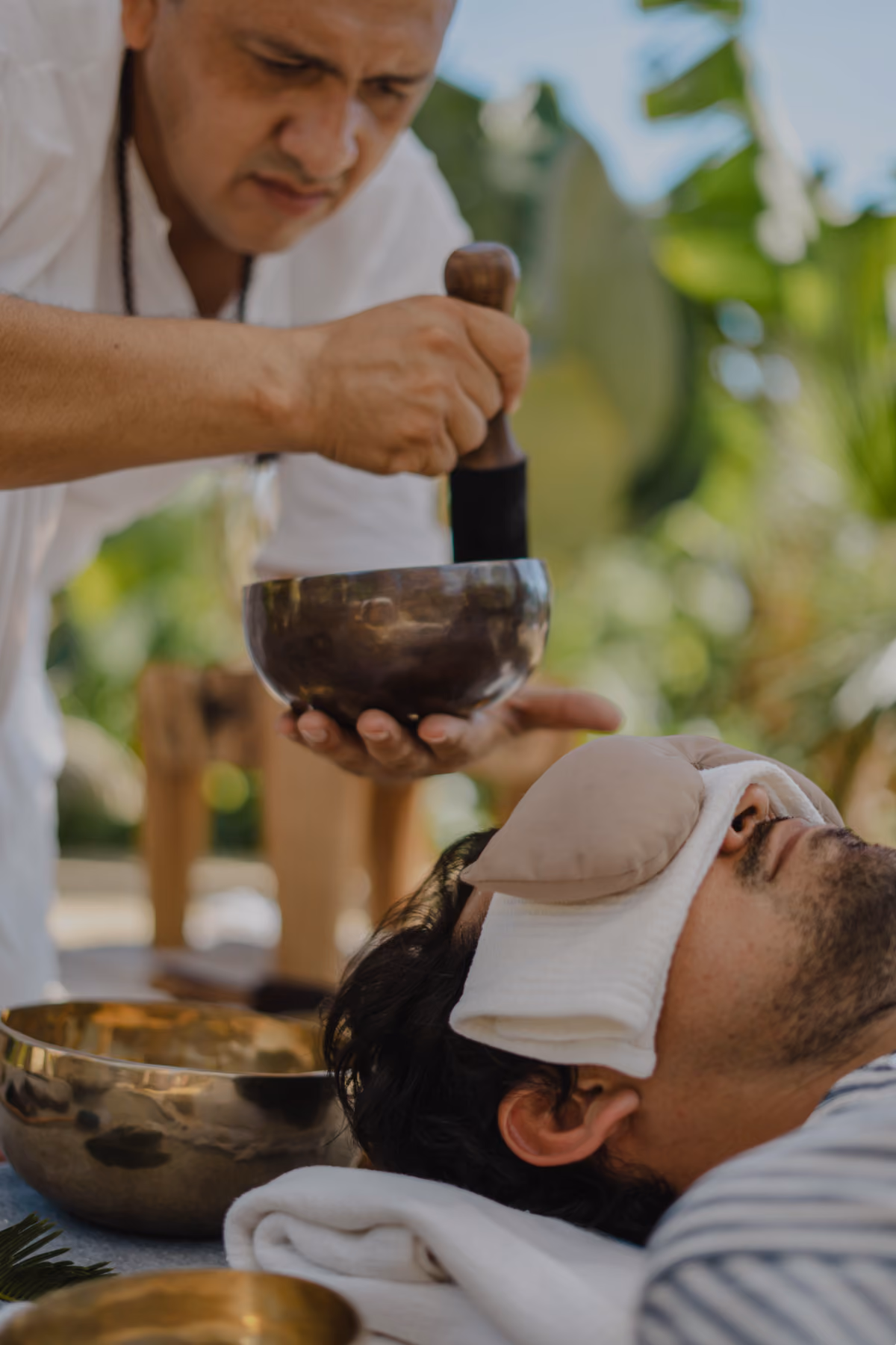 Healer placing a singing bowl over a guest during treatment
