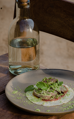 Small plate with fresh greens beside a bottle of water