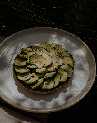 Thinly sliced avocado and cucumber tart on a plate