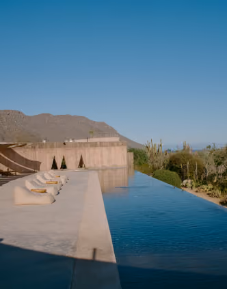 Infinity pool edge overlooking desert mountains and sky