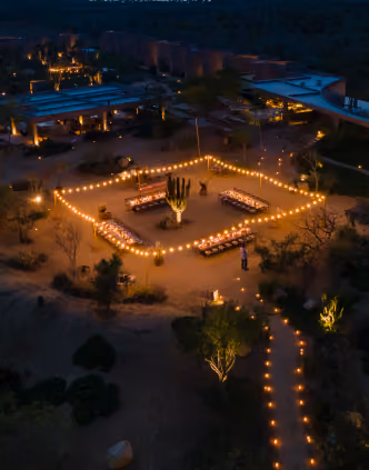 Aerial night view of a candlelit outdoor event in the desert