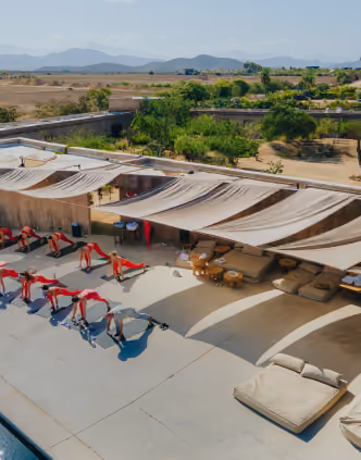 Pool deck with shaded daybeds and red loungers