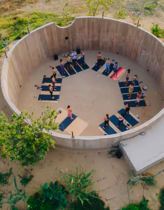 Group yoga session inside a circular open-air courtyard